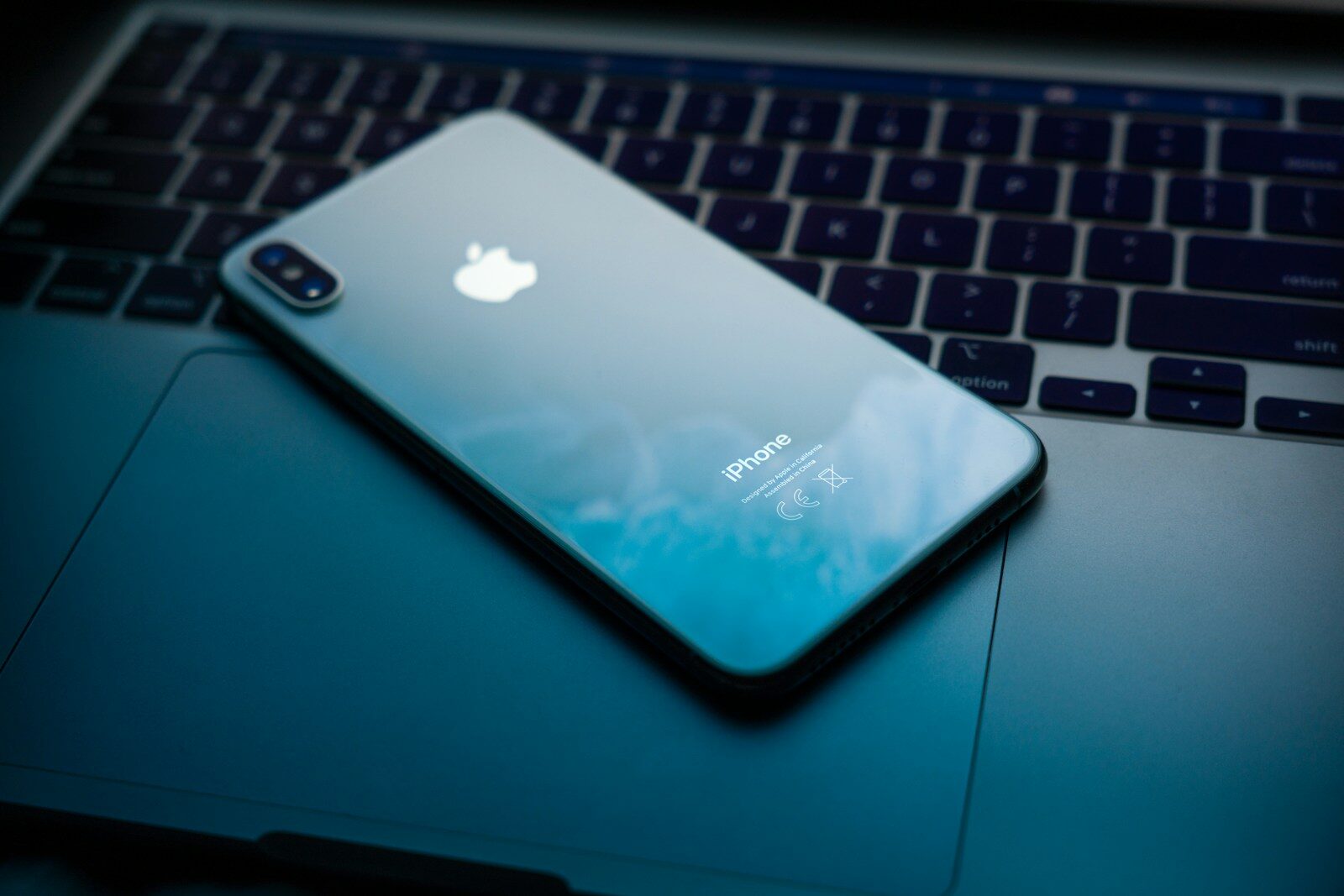 an iphone sitting on top of a laptop computer